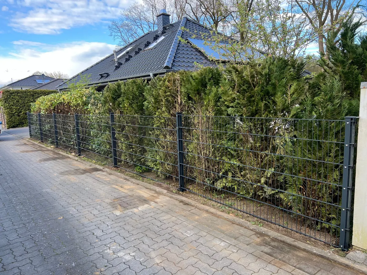 Neue Zaunanlage mit Doppelstabmatten und Granit-Kantensteinen an der Straße
