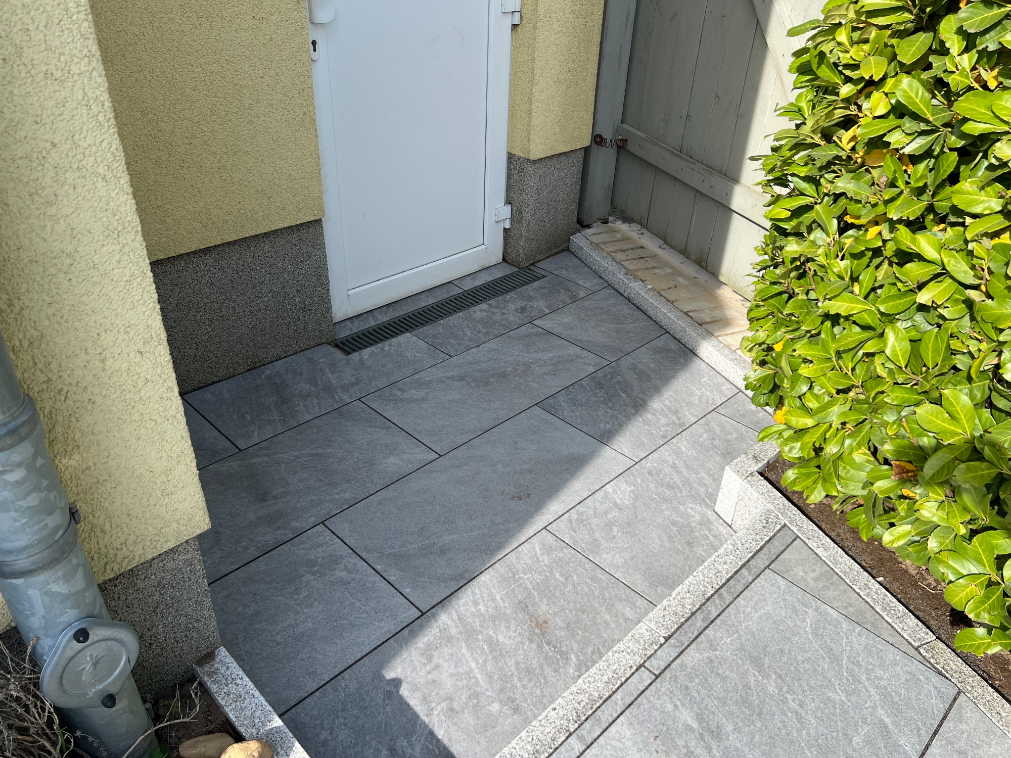 Anthrazitfarbene Platten vor der Haustür mit Graniteinfassung