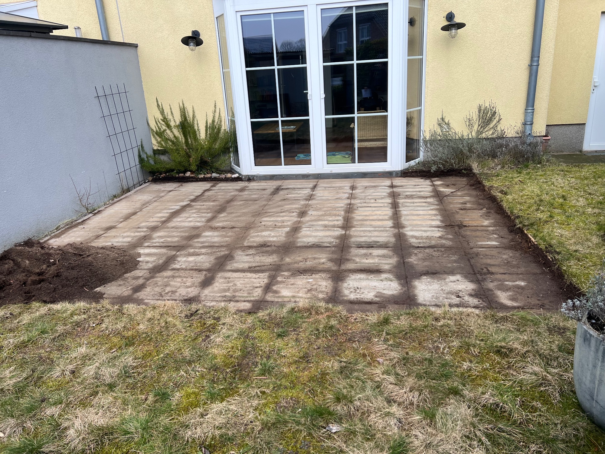 Frisch verlegte Betonplatten während der Bauphase vor dem Rasen