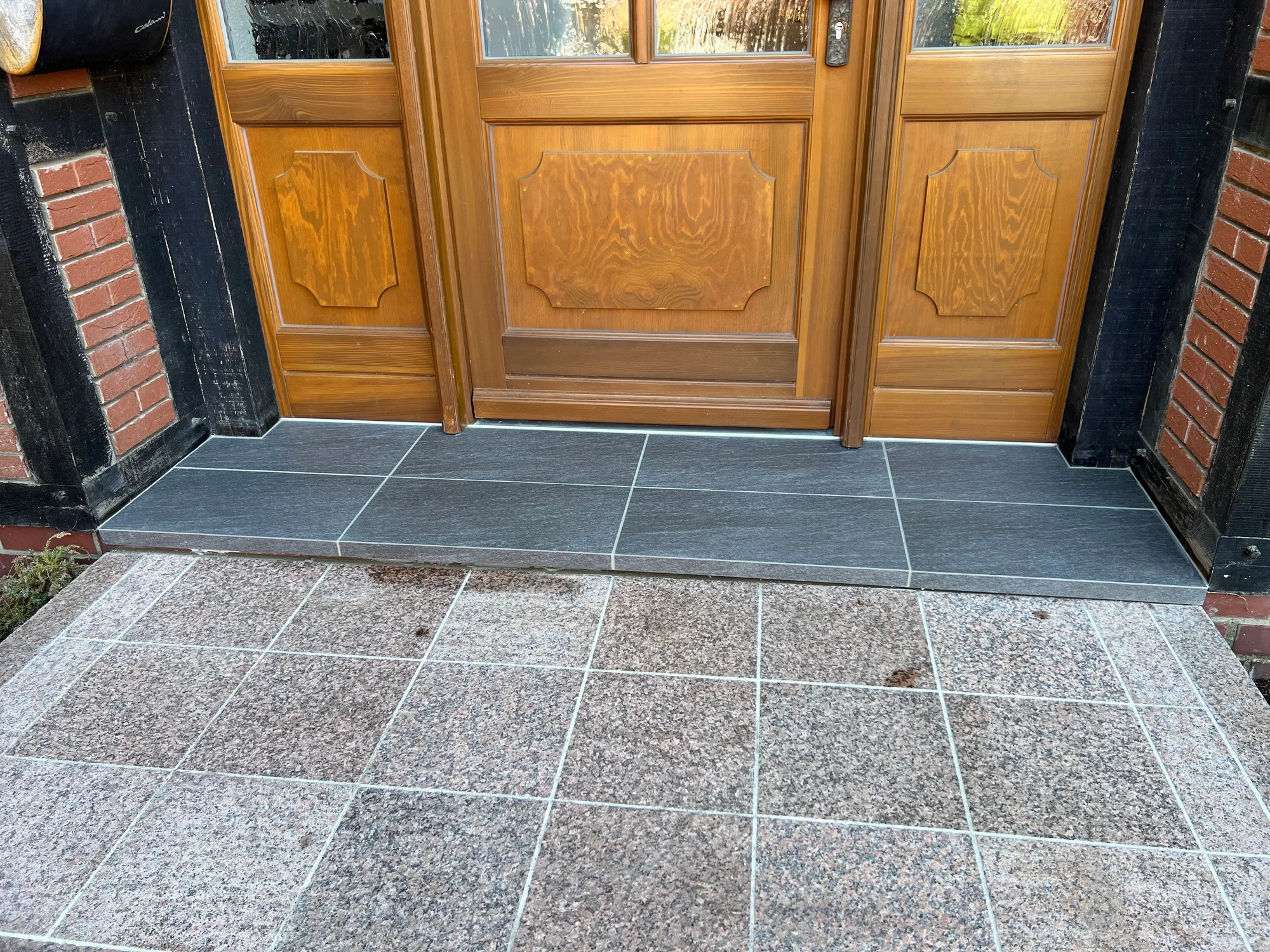 Granitpodest vor Holztür, frisch verfugt